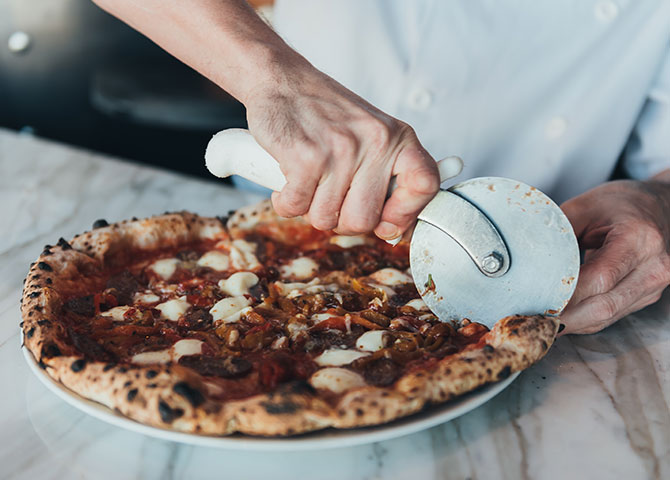 A rustic wood-fired pizza at Fabricca (© The McEwan Group)
